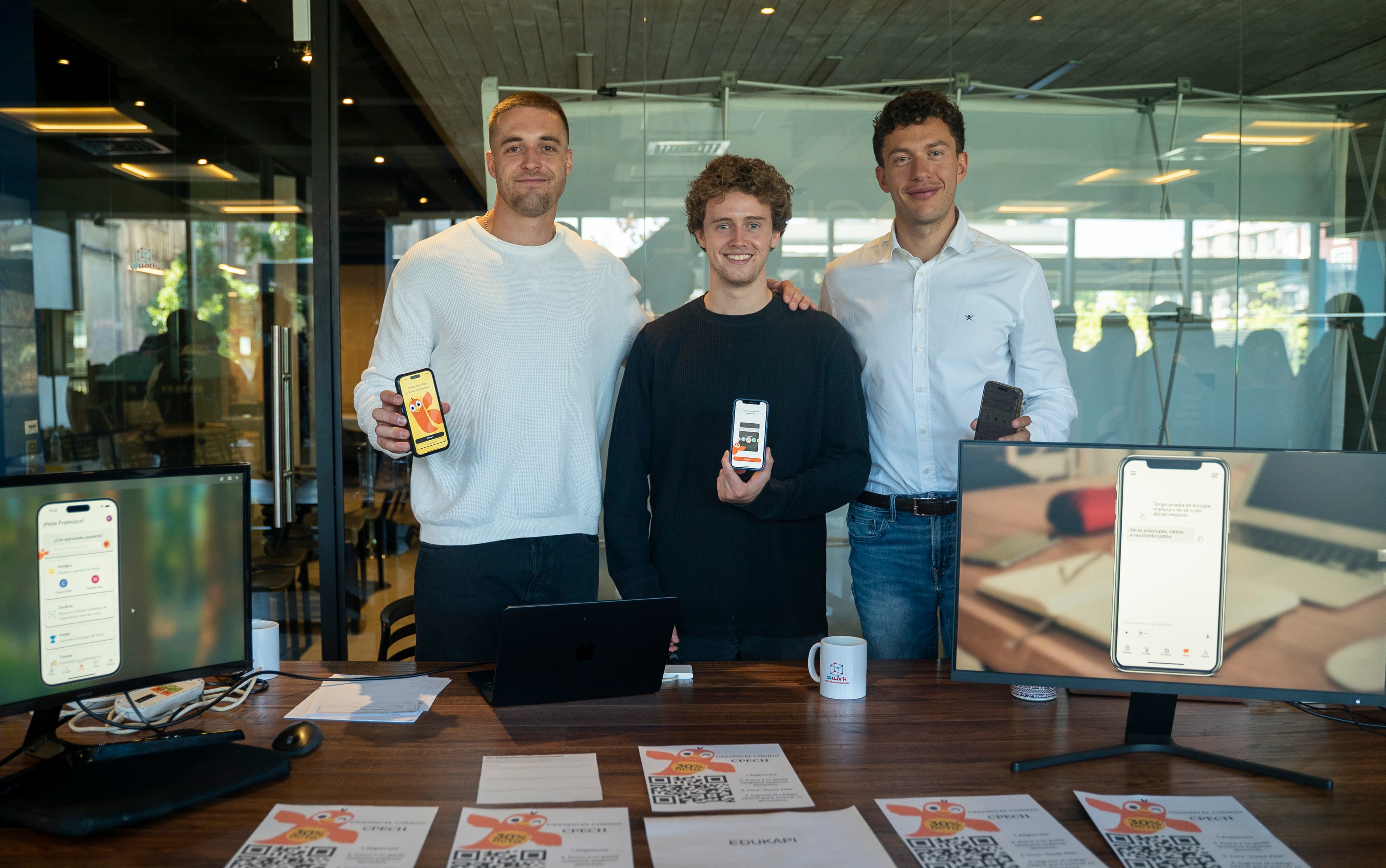 El equipo de Edukapi en su oficina de Santiago, mostrando la app en sus teléfonos.